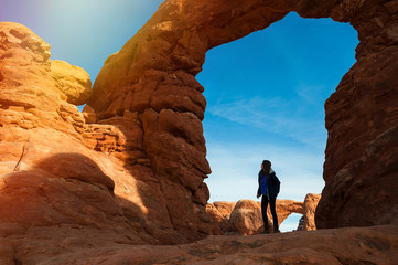 Wall Mural - Young woman traveler with backpack hiking the Turret Arch, Arches National Park in Utah