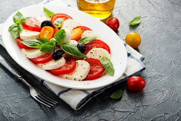 Wall Mural - Delicious caprese salad with  tomatoes,mozzarella cheese and fresh basil leaves. Italian food. top view