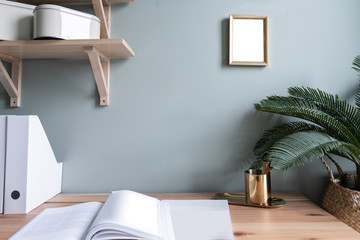 Cozy working space with wooden table ,wooden shelf and artificial plant in the back / Cozy Interior concept /Gold Decoration