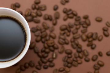 A cup of coffee on a brown background.