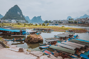 Wall Mural - Scenic landscape at Yangshuo County of Guilin. Li River (Lijiang River). Pleasure boats at the pier in Yangshuo Town, China.