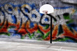 Urban basketball hoop inner city innercity wall and asphalt in outdoor park graffitti