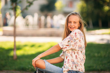 Wall Mural - young teenage girl sits on the bench