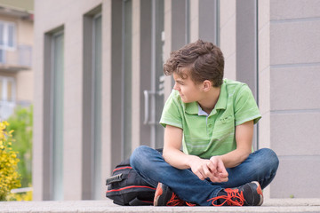 Wall Mural - Outdoor portrait of teen boy 14 years old with backpack on the first or last school day. Back to school after vacation.