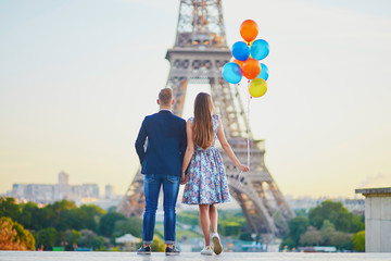 Wall Mural - Couple in Paris with bunch of balloons looking at Eiffel tower