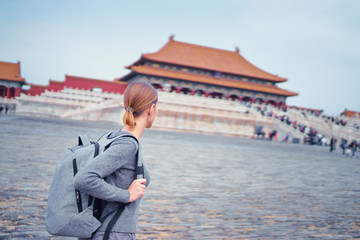 Wall Mural - Enjoying vacation in China. Traveling young woman with rucksack in Forbidden City, Beijing.