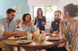 © jackfrog - bunch of multi-ethnic friends gathered around a table for breakfast