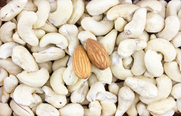 peeled almonds two walnuts on a cashew background many fruits light gray base mix snack