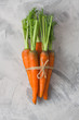 Bunch of fresh carrot with green leaves tied with twine