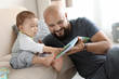 © New Africa - Dad reading book with his little son in living room