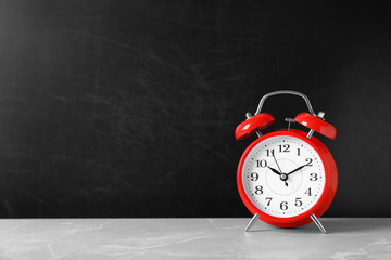 Poster - Alarm clock on table against color background. Time concept