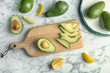Flat lay composition with ripe avocados and lemon on marble background