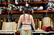 © altoimages/Stocksy - Female Worker Looking At Fabrics And Cardboard At Sofa Workshop
