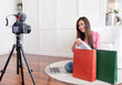 © weedezign - Asian young female blogger recording vlog video with review cloths T-shirt at home online influencer on social media concept.live streaming viral.