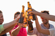 © ManuPadilla - Cheers! Group of happy young people are toasting with bottles of beer in the beach. Celebration concept