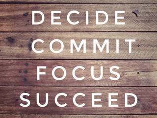 Wall Mural - Motivational and inspirational quote - ‘ Decide, commit, focus, succeed’ on a wooden wall. With vintage styled background.