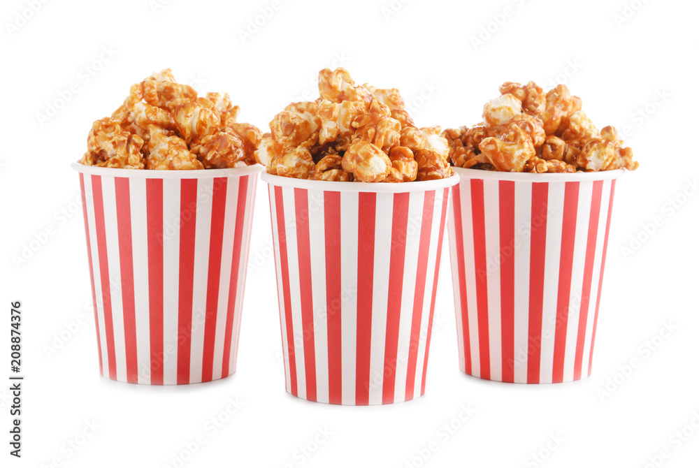 Cups with tasty caramel popcorn on white background