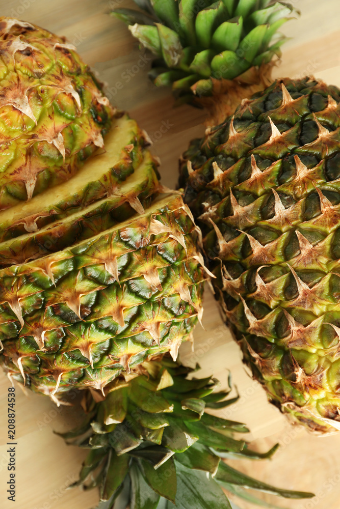 Ripe fresh pineapples on wooden table