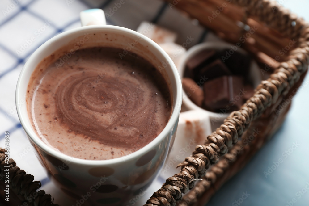 Cup of tasty hot chocolate on wicker tray