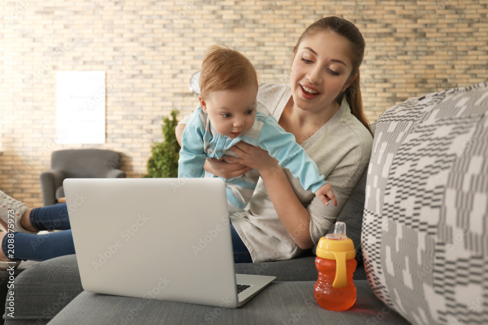 Young mother with baby working at home