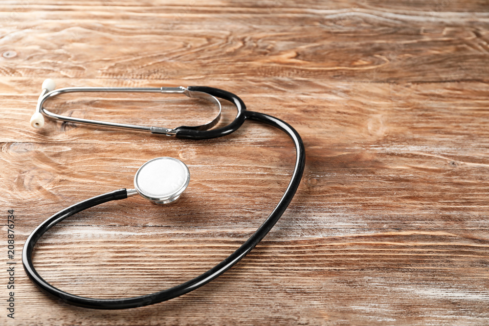 Stethoscope on wooden background. Health care concept