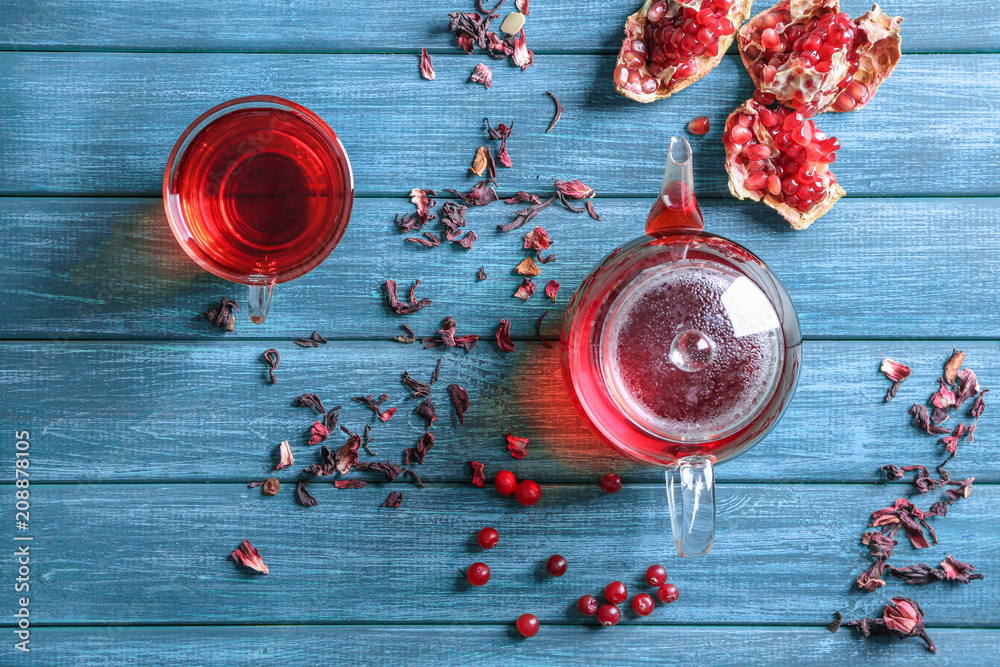 Composition with glass cup of hot aromatic tea on wooden table