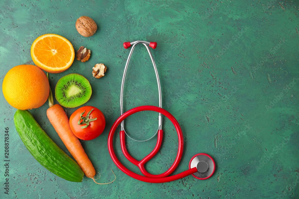 Fresh fruits and vegetables with stethoscope on color background. Healthy food concept