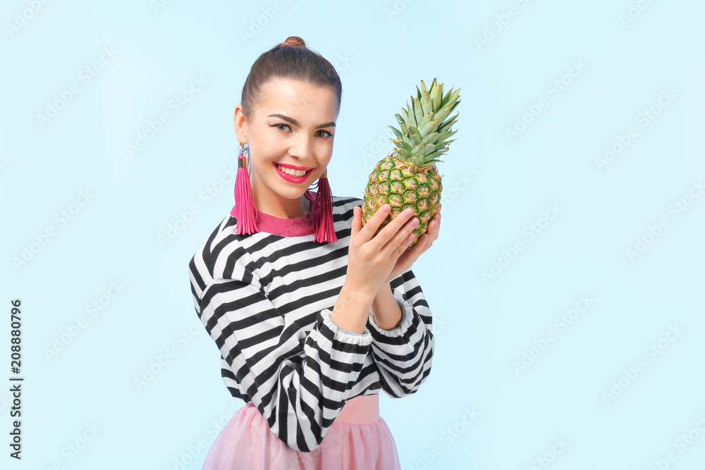 Attractive young woman with pineapple on color background