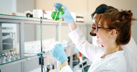 attractive student of chemistry working in laboratory