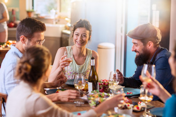 Mixed group of friends having fun while sharing a meal 