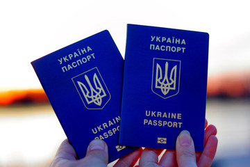 Two Ukrainian biometric passports in hand. Concept of traveling and resting together