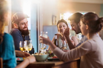 Mixed group of friends having fun while sharing a meal 