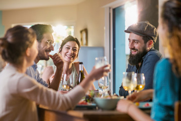 Mixed group of friends having fun while sharing a meal 