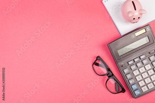 Fotografía Piggy bank and calculator on color background, top view.