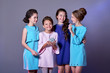 Group 4 happy smiling young teen girls. Fashion lady teenager.Stylish elegant four children posing studio in blue dresses, catalog clothes. Girlfriends in beautiful womanly dresses for event,holiday.
