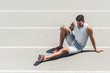 © LIGHTFIELD STUDIOS - fit young jogger with leg injury sitting on running track