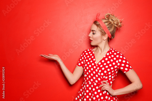 Portrait of beautiful young woman holding something on color background Wallpaper Mural
