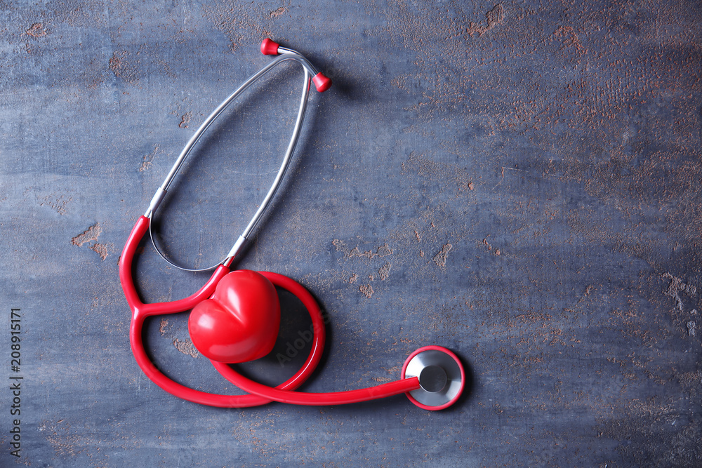 Medical stethoscope with heart on grey background. Health care concept