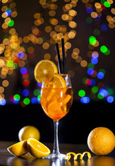 Wall Mural - Fresh cocktail with orange and ice on bar lights background