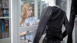 © kustvideo - a young woman in a stylish dress rassatrivaet showcase with a leather vest, which she wants to buy in the boutique