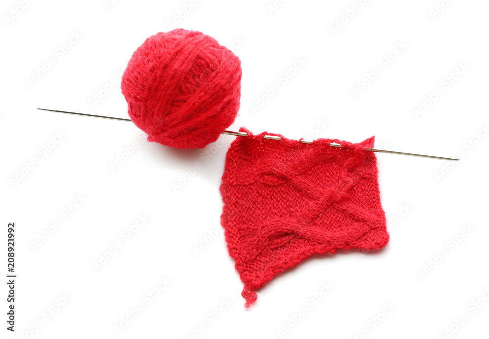 Knitting thread with unfinished clothes on white background