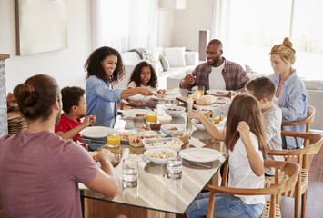 Two Families Enjoying Meal At Home Together