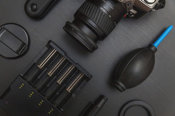 Sticker - Top view of work space photographer with dslr camera system, camera cleaning kit, lens and camera accessory on black table background. Hobby journalism photography technology art concept