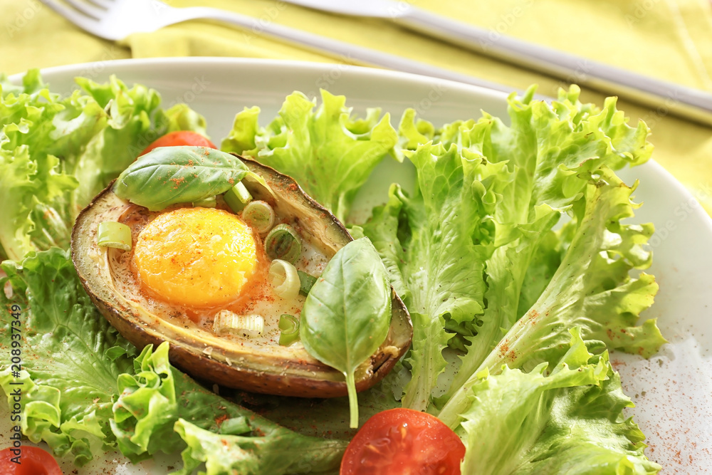 Tasty baked avocado with egg and fresh vegetables on plate, closeup