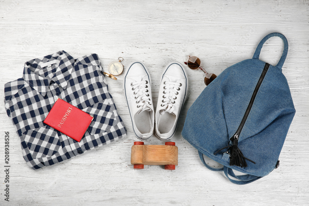 Composition with tourist's stuff on wooden background, top view