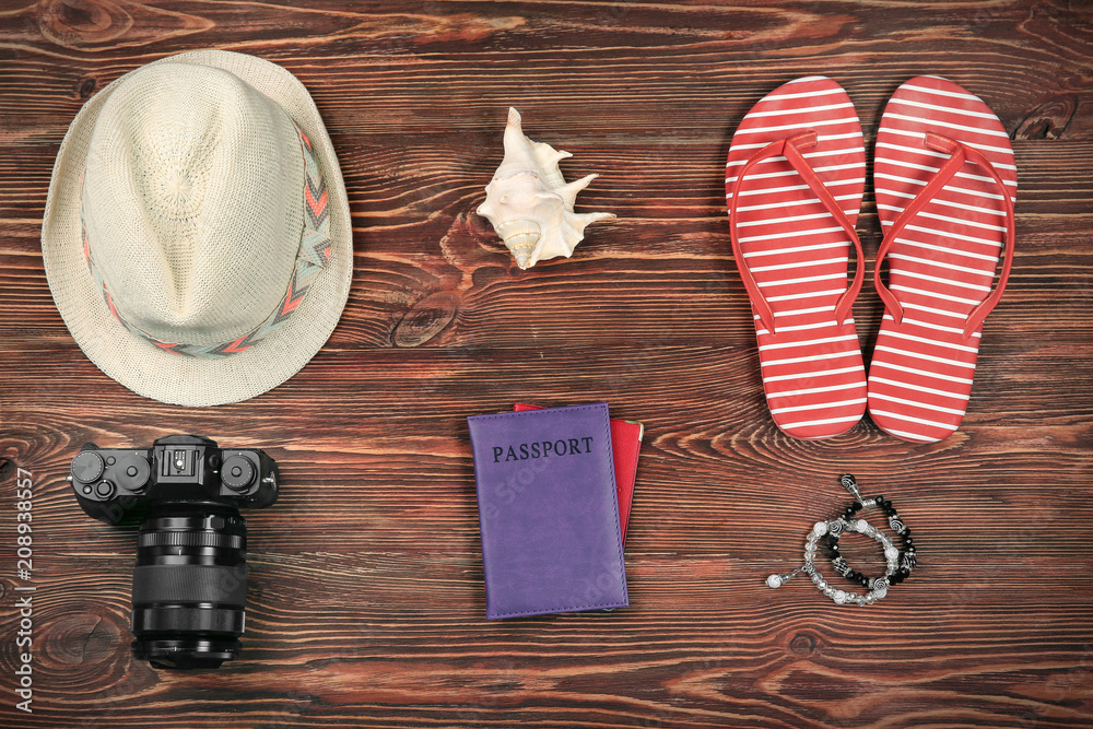Composition with tourist's stuff on wooden background, top view