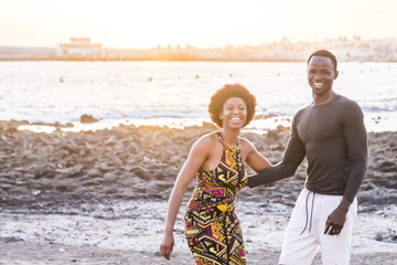 happy black african race skin couple together having fun at the beach in vacation. happiness concept