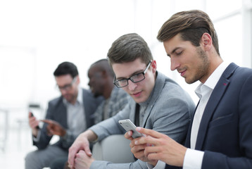 Wall Mural - business colleagues reading SMS on smartphone