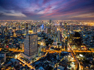 Wall Mural - Aerial view of Bangkok skyline and skyscraper with BTS skytrain Bangkok downtown. Panorama of Sathorn and Silom business district Bangkok Thailand at night.