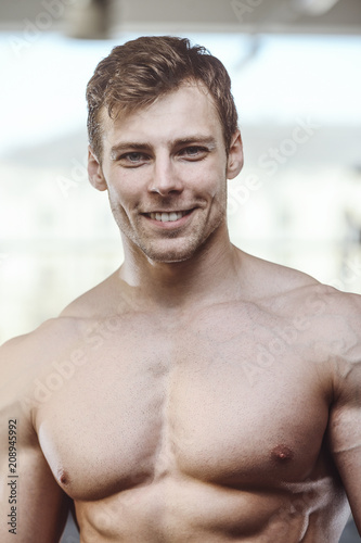 Fotografie, Obraz handsome strong bodybuilder athletic men pumping up muscles with dumbbells